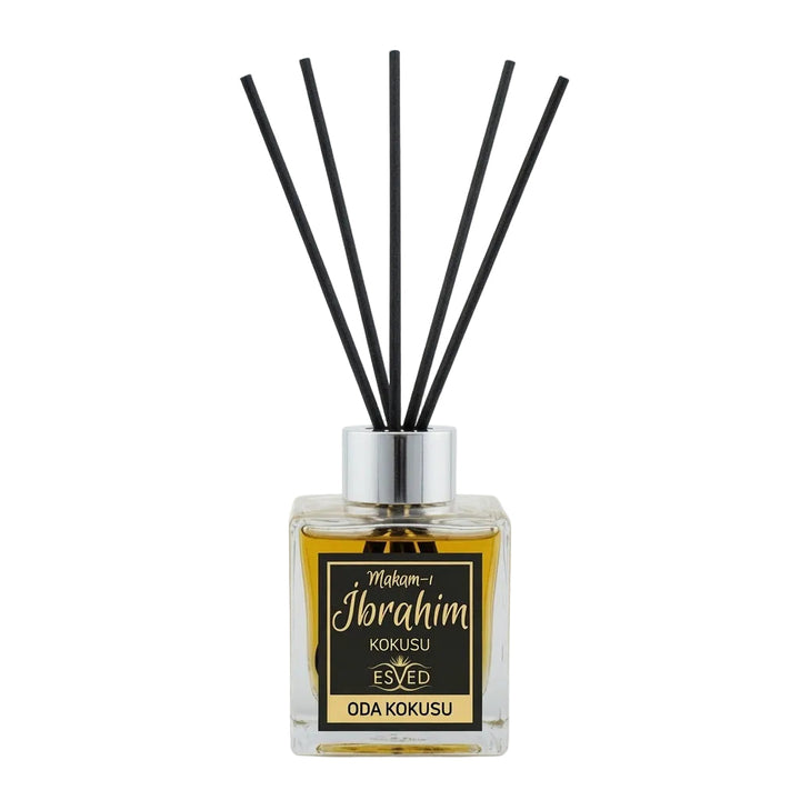 A reed diffuser bottle with a clear glass container filled with amber liquid, a silver cap, and five black reeds. The front label reads 'Mokom-1 Ibrahim KOKUSU ODA KOKUSU' with a black and gold design.